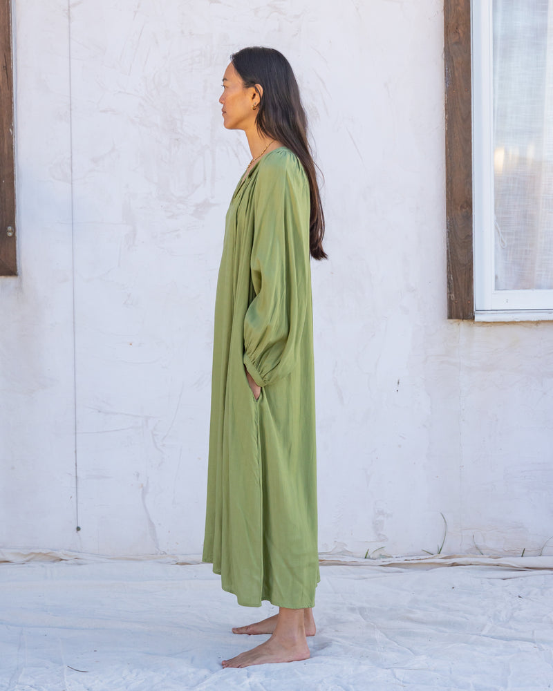 
                  
                    woman dressed in flores organic sugarcane dress in forest green in front of white wall
                  
                